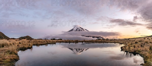 Water reflection in Pouakai Tarn Mountain Lake at sunset