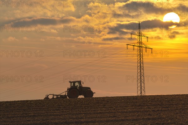 Tractor with plough ploughing on a field
