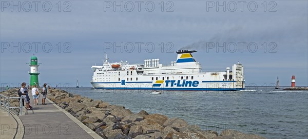 Baltic Sea ferry passes pier light at the entrance to Unterwarnow