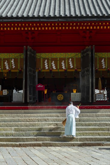 Monk sweeping a staircase with a broom