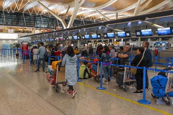 Travellers wait at the counter at the check in