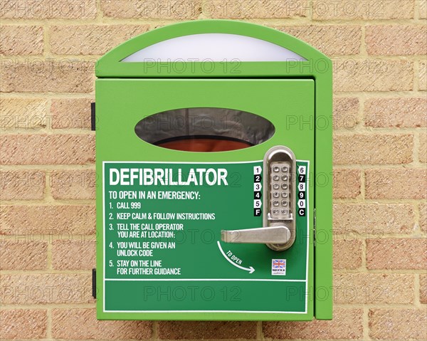 Automated external defibrillator mounted on the wall of a village hall