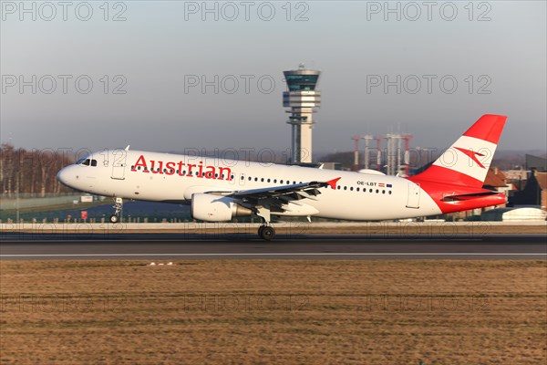 Austrian Airlines airplane landing at the Brussels Airport by the control tower Skeyes