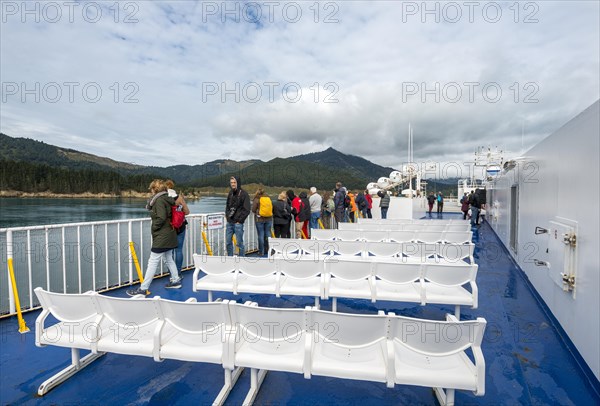 Passengers on deck a ferry in the fjord