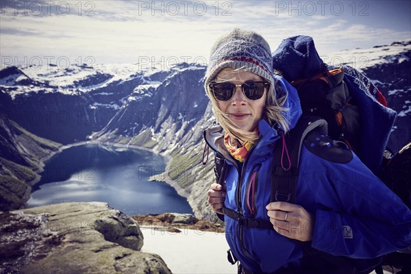 Young woman climbing to Trolltunga