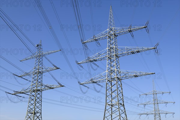 High-voltage pylons in front of a blue sky