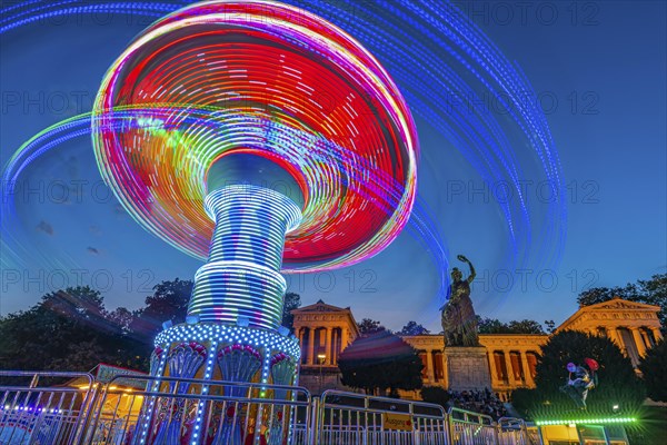 Rotating chain carousel at night in front of the Bavaria