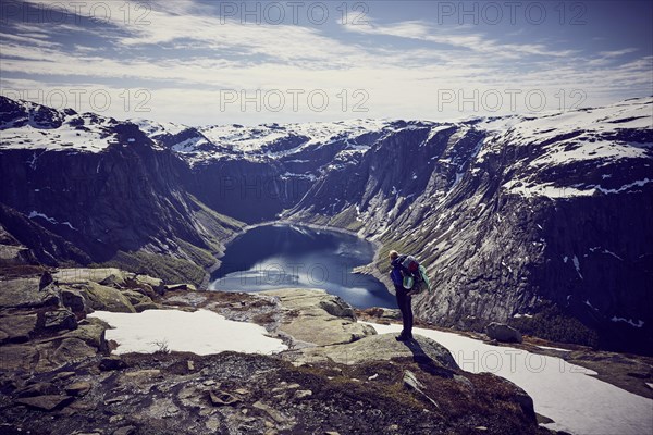 Young woman climbing to Trolltunga