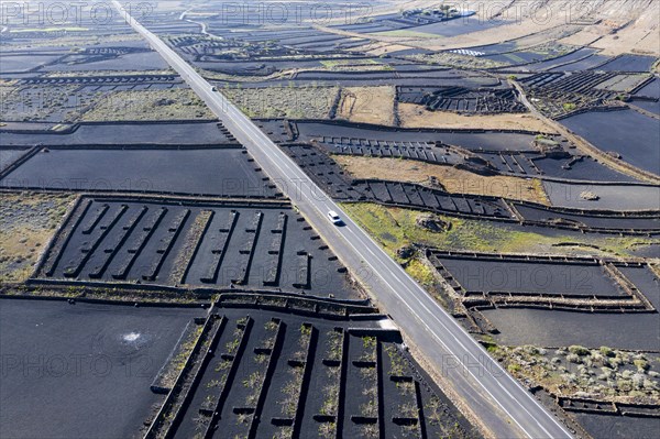 Country road through fields with black lava gravel