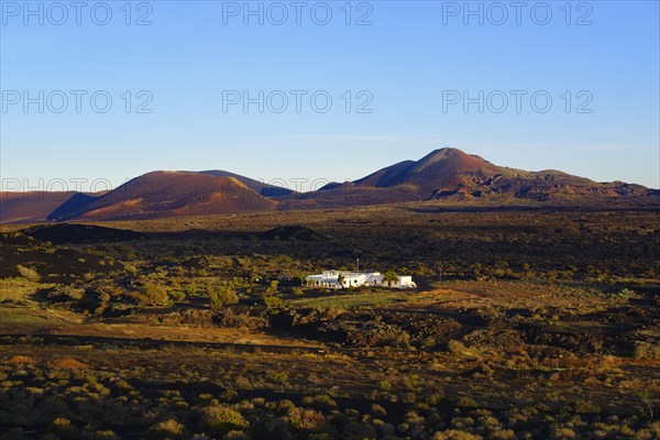 Villa in lava landscape in front of fire mountains