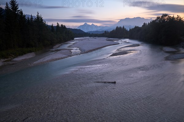 View from a bridge after sunset to the wide Isar riverbed with the Wetterstein range in the background