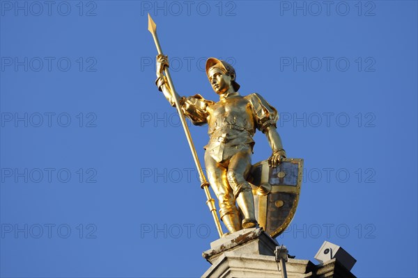 Golden figure with lance on gable of a guild house