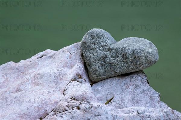 Stone in the shape of a heart lies in the notch of another stone