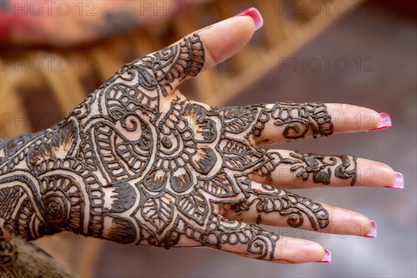 Mehendi tatooed hand of Indian bride on her wedding eve