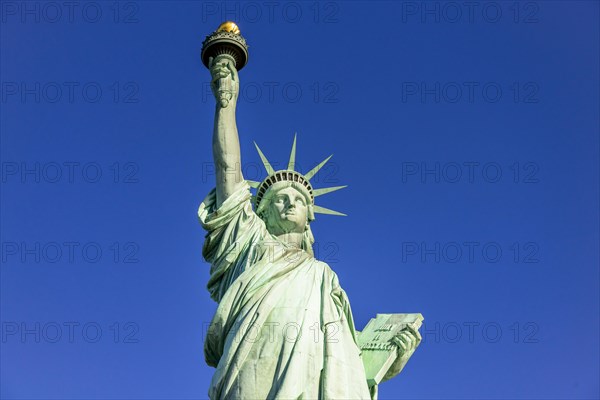 Statue of Liberty in front of blue sky