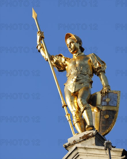 Golden figure with lance on gable of a guild house