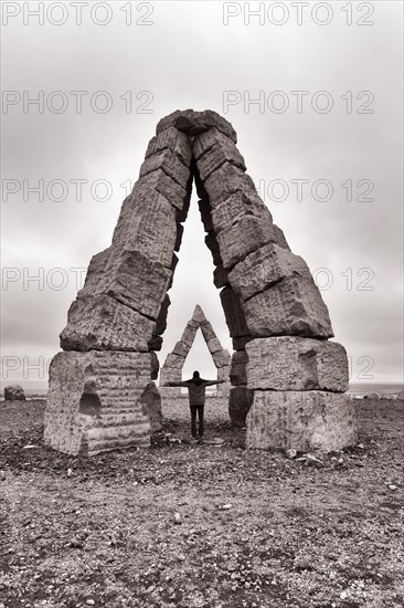 Visitor standing in monumental stone gate