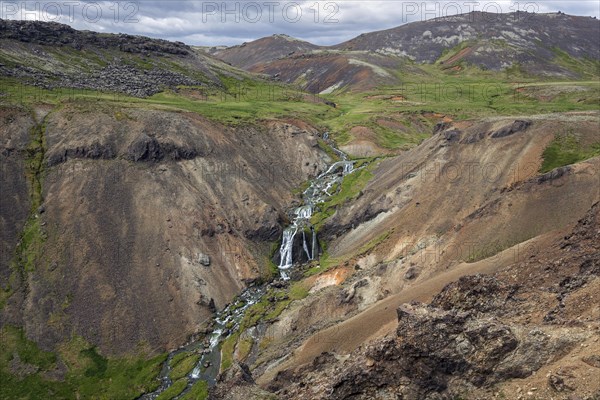 Volcanic landscape and waterfall on the hiking trail to Reykjadalur