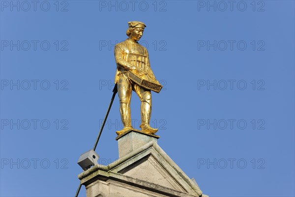 Golden figure on the gable of a guild house