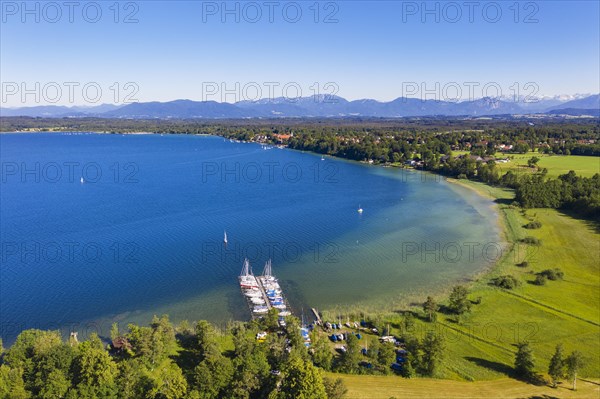 Boat landing stage in lake sides at Lake Starnberger See with alpine chain