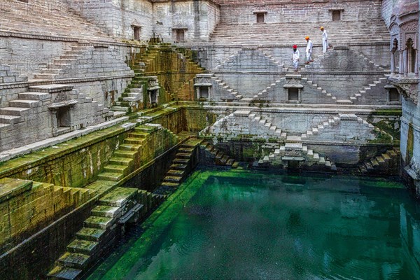 Three men walking down the steps at the stepwell Toorji Ka Jhalra in Jodhpur