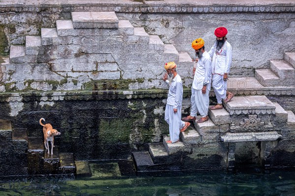 Three men walking down the steps at the stepwell Toorji Ka Jhalra in Jodhpur