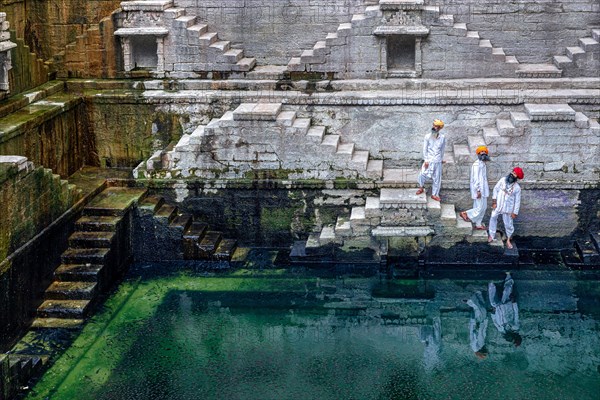 Three men walking down at the stepwell Toorji Ka Jhalra in Jodhpur