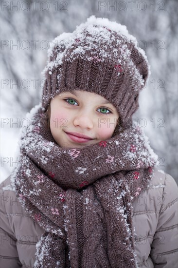 Girl with a snow-covered wool cap in winter