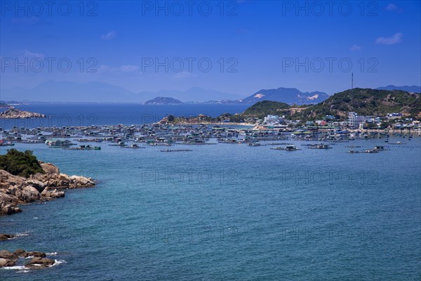 Rocky coastal landscape with floating houses near Vinh Hy