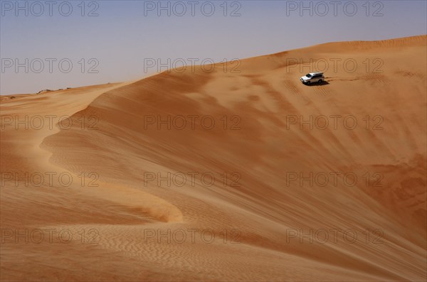 Off-road vehicle drives on sand dune