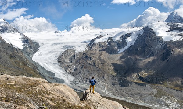 Hiker looks from the mountain Unterrothorn onto the glacier tongue of the Findel Glacier