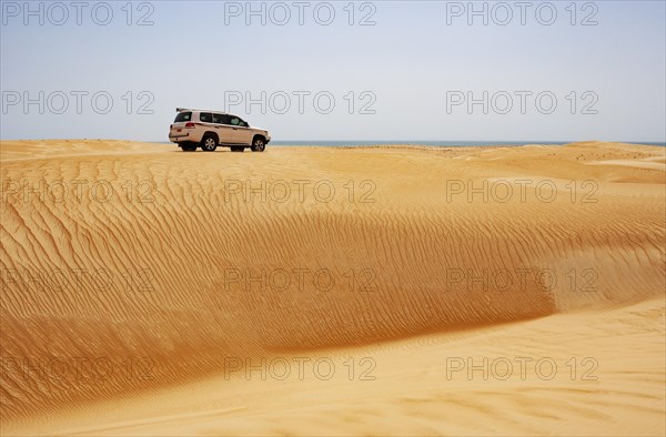 Off-road vehicle drives on sand dune