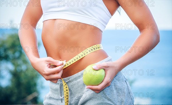 Torso of a young woman with an apple and meter