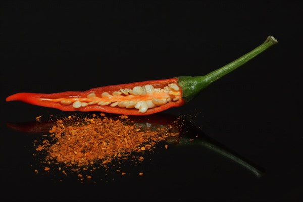 A halved fresh Thai red chili and dried chili powder