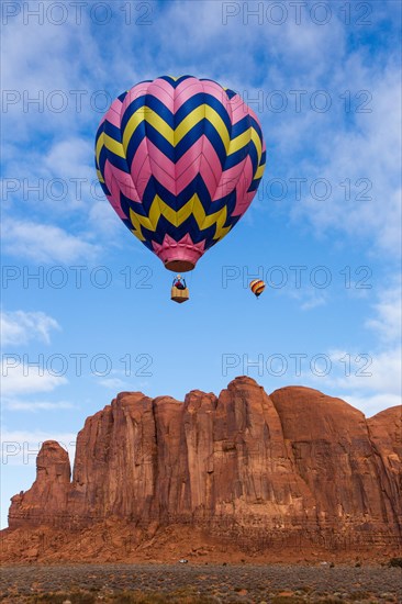 Two hot air balloons fly over Camel Butte