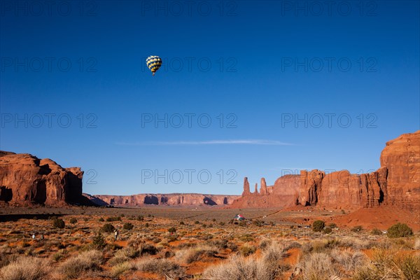 Hot air balloon flying between buttes