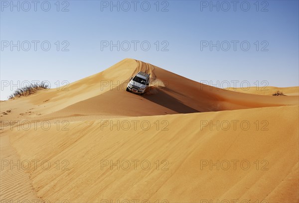 Off-road vehicle drives on a sand dune