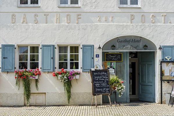 Entrance to the restaurant with menu and flower arrangements