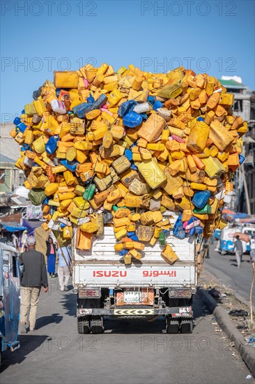 Truck overloaded with yellow plastic bottles and containers