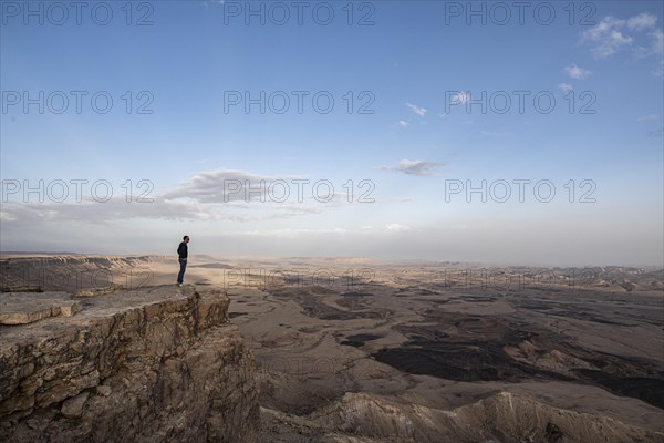 Tourist standing on rock at Maktesh Ramon Crater
