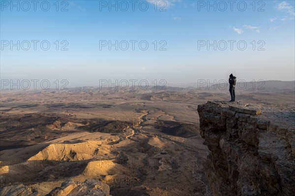 Tourist standing on rock at Maktesh Ramon Crater