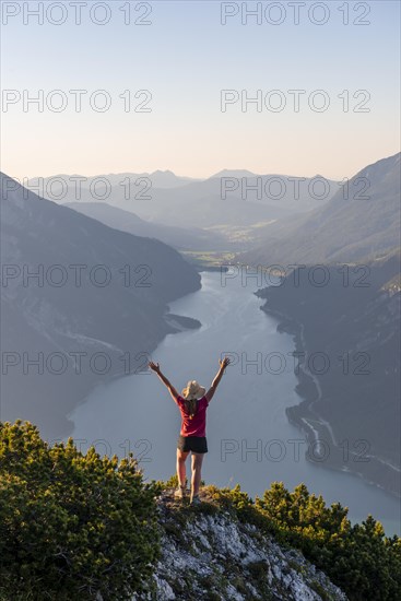 Young woman stretches arms in the air