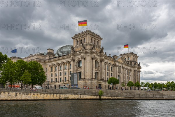 Reichstag with waving German flag at the Spree