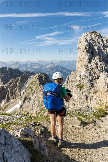 Mountaineer with backpack looking over mountains