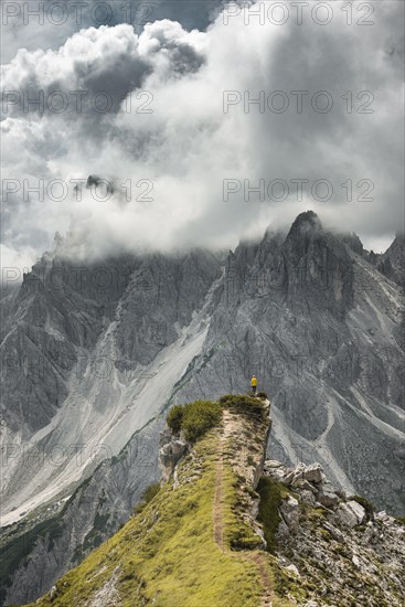 Woman in yellow jacket standing on a ridge