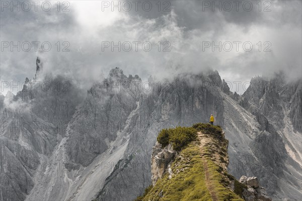 Woman in yellow jacket standing on a ridge