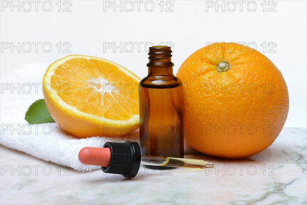 Orange and orange oil in bottle with pipette
