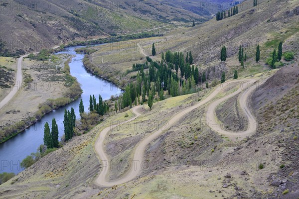 Gravel road winding along the slope above the Rio Alumine