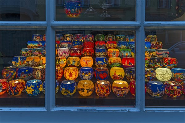 Colourful painted illuminated lanterns with Christmas motifs in a shop window