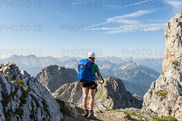 Mountaineer with backpack looking over mountains